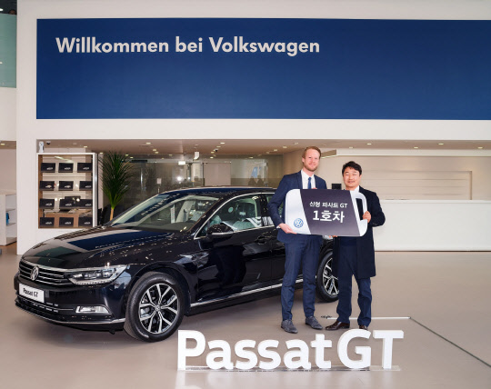 폭스바겐코리아가 신형 파사트 GT 1호차를 소비자에게 전달했다. 왼쪽부터 슈테판 크랍 폭스바겐코리아 사장과 이형서씨가 파사트 GT를 배경으로 기념촬영을 하고 있다.<폭스바겐코리아 제공>